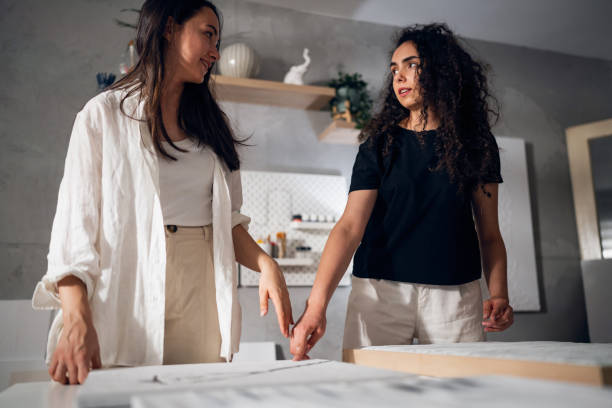 istock Two sisters artists framing a painting together 1415820330