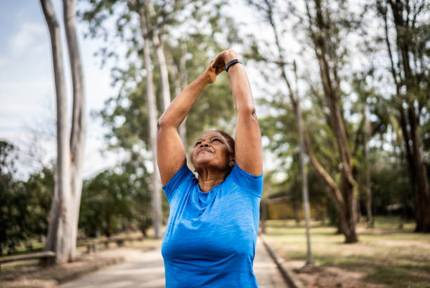 istock Senior woman stretching in a park 1415820906