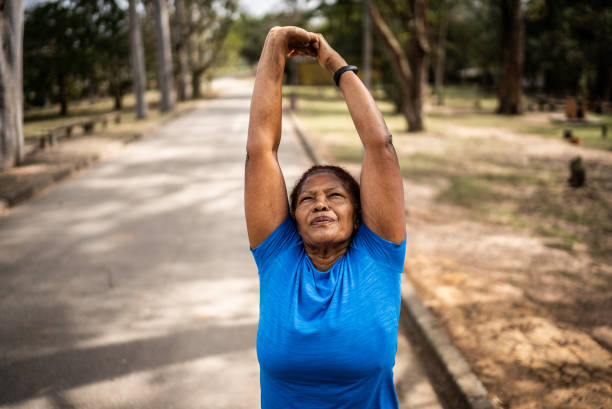 istock Senior woman stretching in a park 1415820925