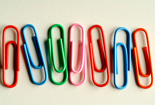 Colored paper clips on white background.