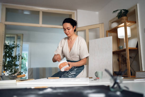 istock Young woman painting with acrylics in her studio 1415821659
