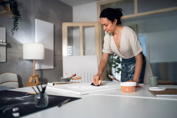 istock Young woman painting with acrylics in her studio 1415821666
