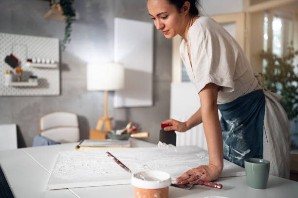 istock Young woman painting with acrylics in her studio 1415821833