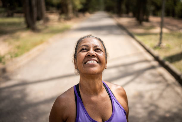 kontemplacyjna starsza kobieta spoglądająca w górę w parku - exercising motivation looking up african descent zdjęcia i obrazy z banku zdjęć