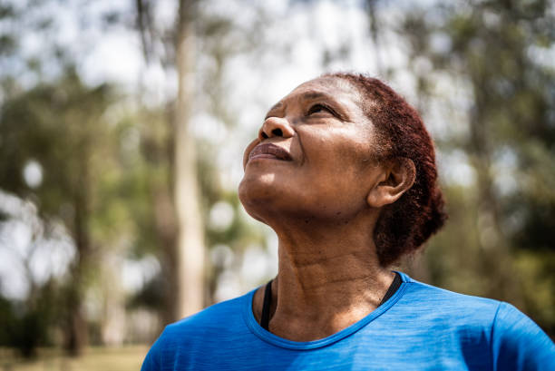 kontemplacyjna starsza kobieta spoglądająca w górę w parku - exercising motivation looking up african descent zdjęcia i obrazy z banku zdjęć