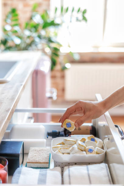 istock woman hold dishwashing tablet at bright kitchen 1415825511