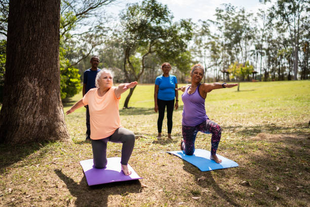 istock Senior friends doing yoga in a park 1415826751