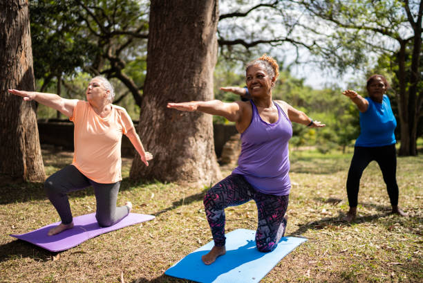 istock Senior friends doing yoga in a park 1415826780