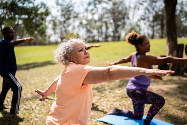 istock Senior friends doing yoga in a park 1415826781