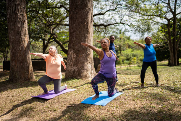 istock Senior friends doing yoga in a park 1415826784