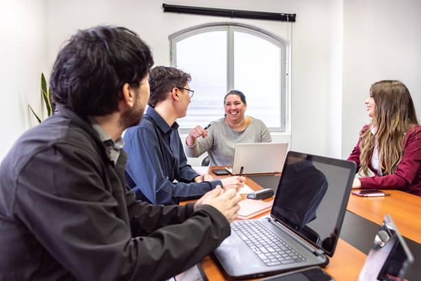 istock People working on laptops during a meeting 1415826861