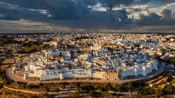 Overview of Ostuni (BR), the white city perched on the hill, with the typical white houses. Aerial photo with the drone of June 2022 photo taken at dawn.