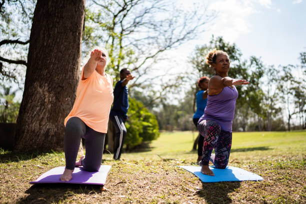 istock Senior friends doing yoga in a park 1415828192