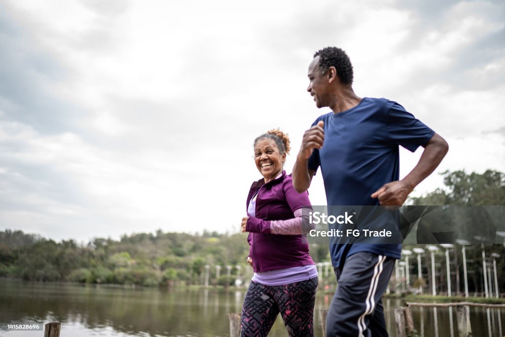 Senior couple jogging in a park Exercising Stock Photo