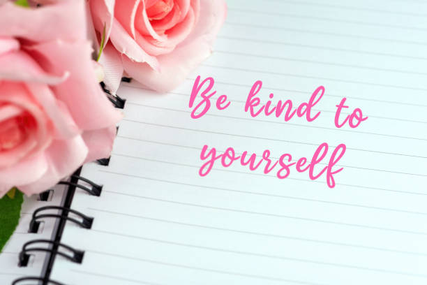 Note pad with inspirational quotes text - Be kind to yourself stock photo