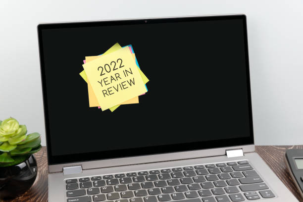 Adhesive note with text 2022 year in review on laptop screen stock photo