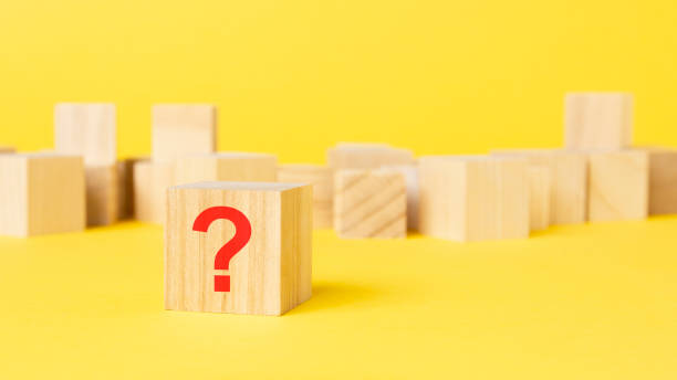 istock Question mark drawn on wooden block over yellow background with copy space. 1415831266