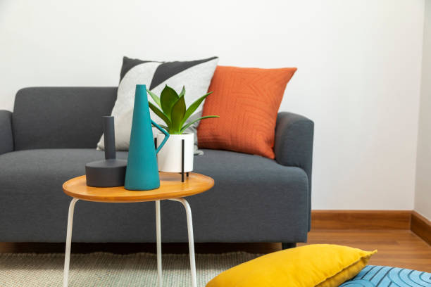 istock Yellow, blue and orange pillows on grey sofa. 1415831440