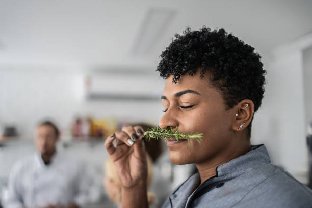 Woman smelling fresh herbs in a cooking class