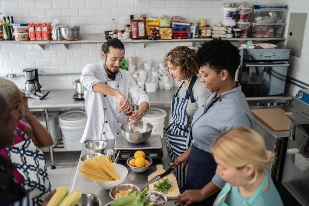 istock Chef giving instructions to adult students in a cooking class 1415832188