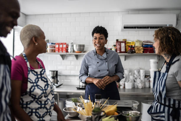 istock Chef giving instructions to adult students in a cooking class 1415832244