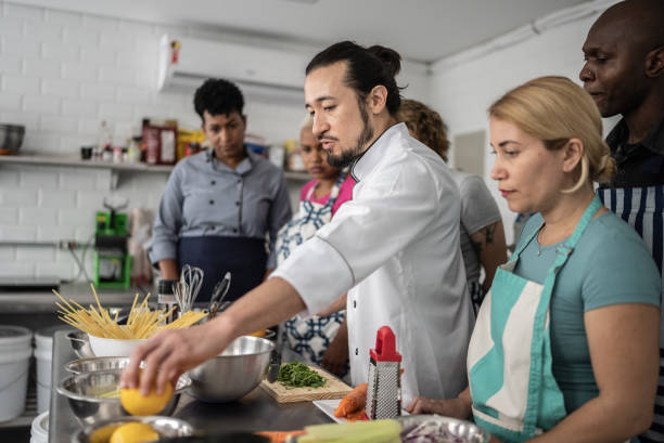 istock Chef giving instructions to students at cooking class 1415832511
