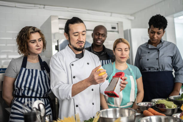 istock Chef giving instructions to students at cooking class 1415832513
