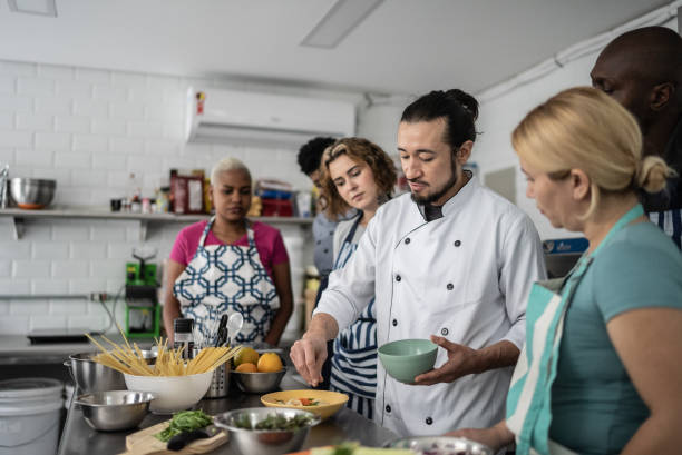istock Chef giving instructions to students at cooking class 1415832514