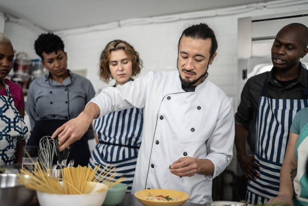 istock Chef giving instructions to students at cooking class 1415832531