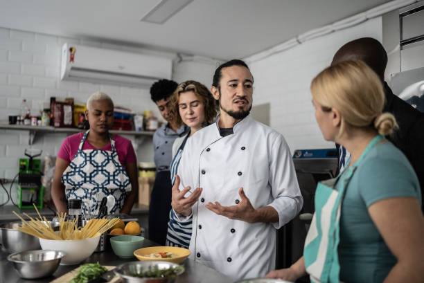istock Chef giving instructions to students at cooking class 1415832533