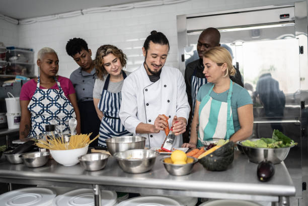 istock Chef giving instructions to students at cooking class 1415832551