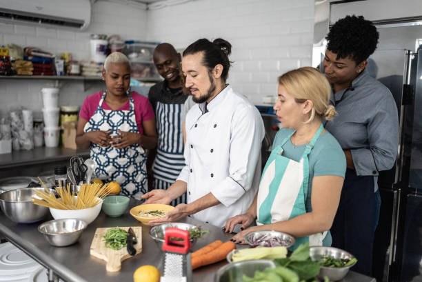 istock Chef giving instructions to students at cooking class 1415832585