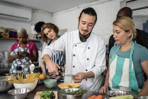 istock Chef giving instructions to students at cooking class 1415832588