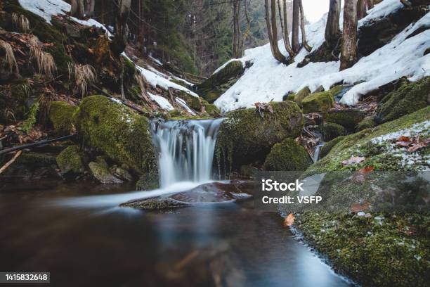 Clear Water Photographed With Long Exposure Time Through Flowing Rocks Covered With Moss With Autumn Colours Of Leaves And Snow Cover Around Beskydy Mountains Czech Republic Heart Of Europe Stock Photo - Download Image Now