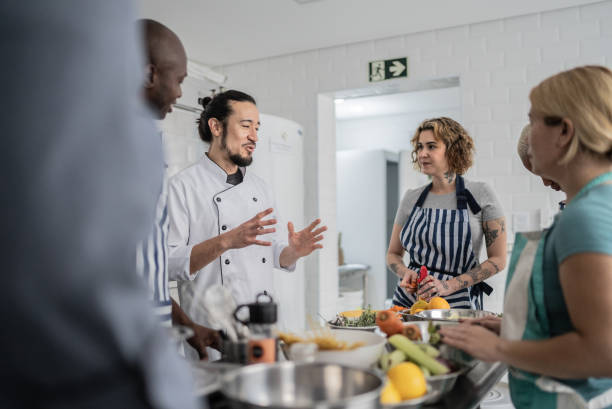 istock Chef giving instructions to students in a cooking class 1415832716