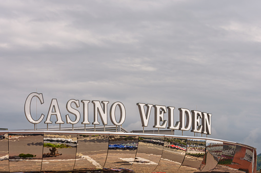 Velden am Wörthersee, Austria - August 7, 2022: Casino Velden sign in the Austrian city of Velden am Wörthersee against a cloudy sky