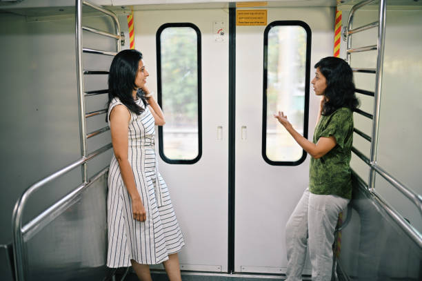 istock Two women standing at a train door and discussing with each other 1415837588