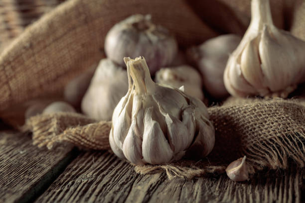 istock Garlic on an old wooden table. 1415838030
