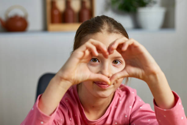 istock Little girl, making hearts from hands, love 1415838080