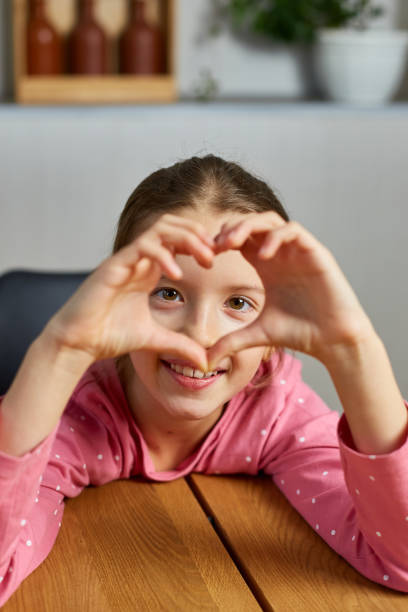 istock Little girl, making hearts from hands, love 1415838085
