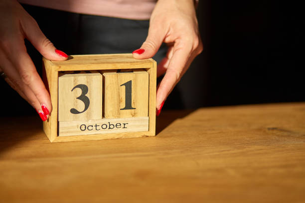 여자 손 변경, 10 월 31 일에 나무 달력에 날짜를 설정합니다. - calendar october countdown event 뉴스 사진 이미지
