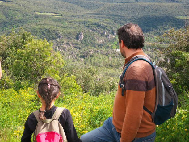 A father and daughter on a hike looking at the landscape
