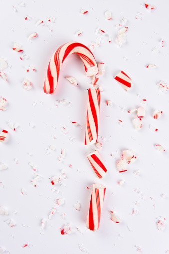 High angle view of a shattered candy cane on white.