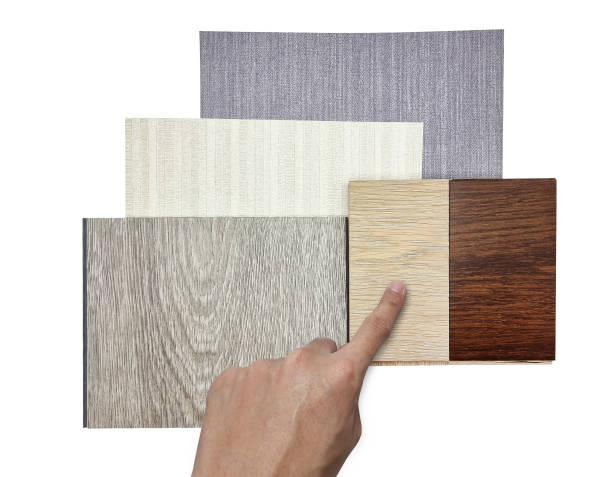 istock interior architect choosing finishing material samples including vinyl flooring, ash and italian walnut engineered flooring,  fabric interior wallpaper isolated on white background with clipping path. 1415843400