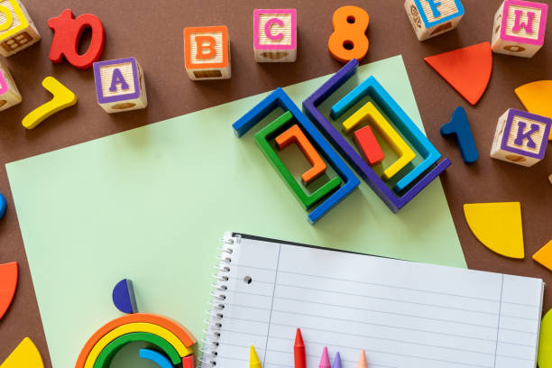 Wooden kids toys on colourful paper. Educational toys, blocks, pyramid, pencils, numbers, rainbow. Toys for kindergarten, preschool or daycare. Copy space for text. Top view. Back to school background juguetes de madera para niños sobre papel de colores. juguetes educativos, bloques, pirámide, lápices, números, arco iris. juguetes para jardín de infantes, preescolar o guardería. espacio de copia para el texto. vista superior. antecedentes de regre
