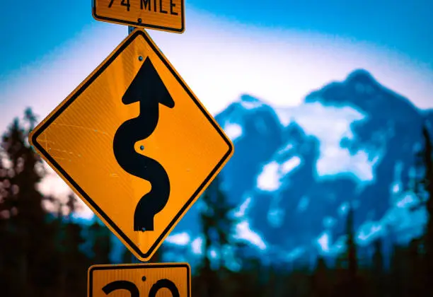 Winding road sign in Mount Baker National Park during sunset