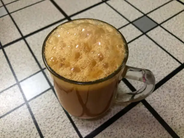 Photo of Tea with milk in a mug or popularly known as Teh Tarik. Malaysian Favorite drink.