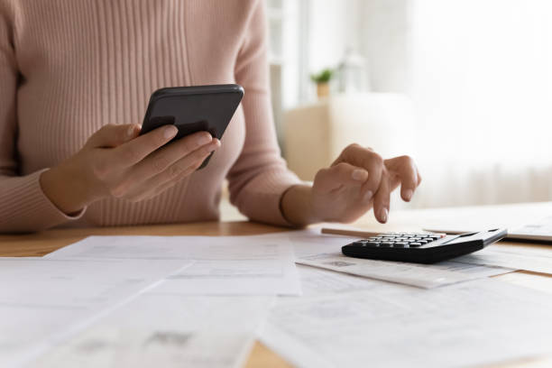 istock Woman makes calculations, pay bills through e-bank app on smartphone 1415850792