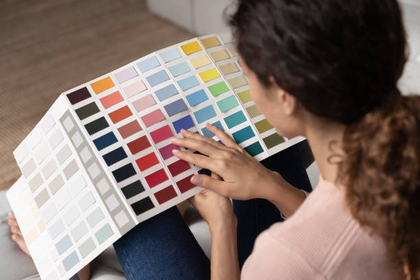 istock View over female shoulder holding pantone samples, close up 1415850810