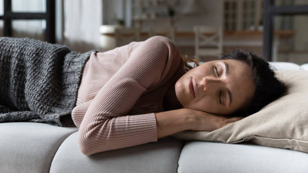 istock Young serene Latin woman sleep on sofa at home 1415850829